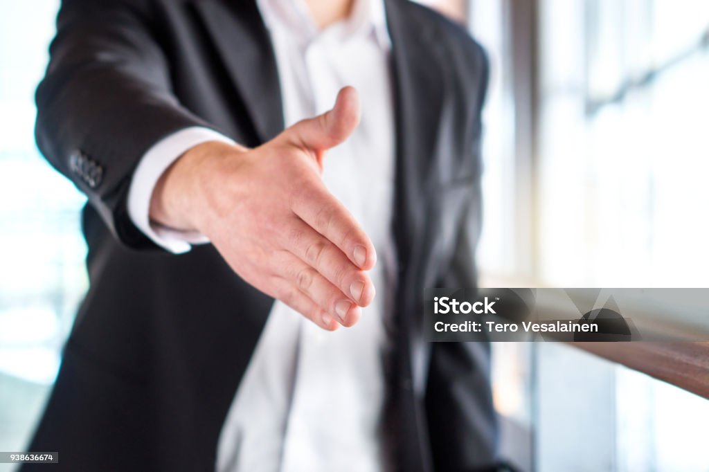 Success, opportunity, deal or agreement. Business man offering and giving hand for handshake in modern office building.