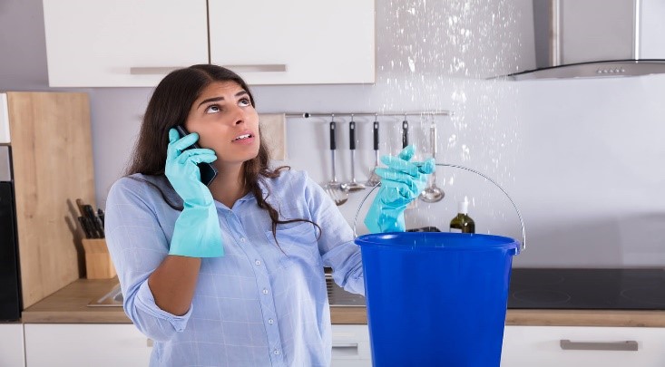 Woman holding a bucket catching a leak