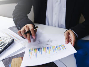 A businessman looking at paperwork with a bar chart.