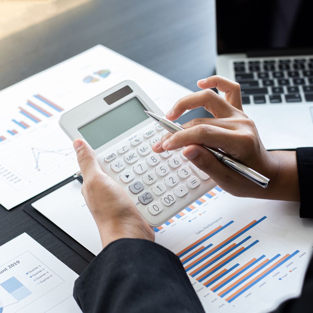 photo of someone going through finances and punching numbers into a calculator