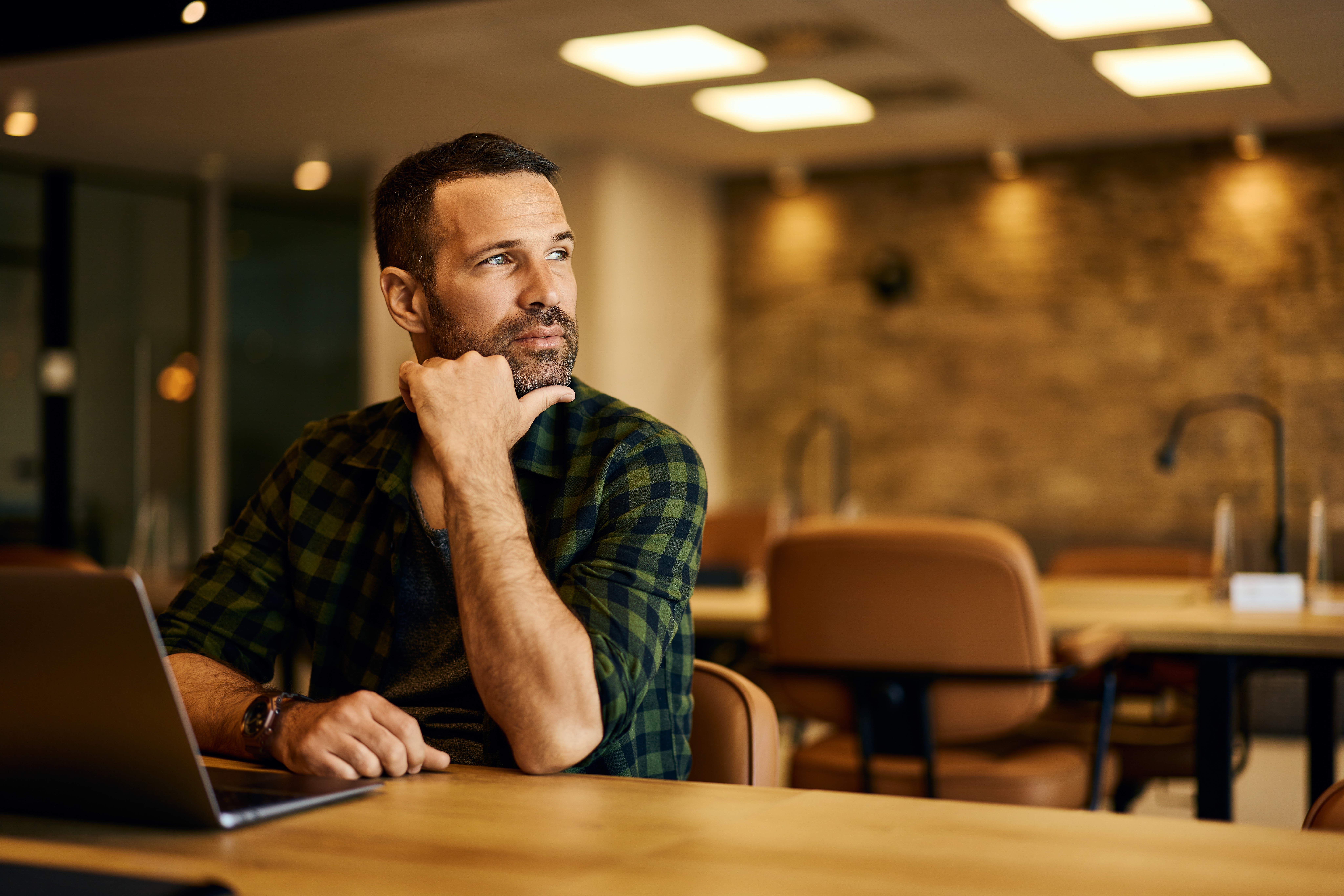 Thoughtful,Businessman,Looking,Through,The,Window,While,Working,Online,In