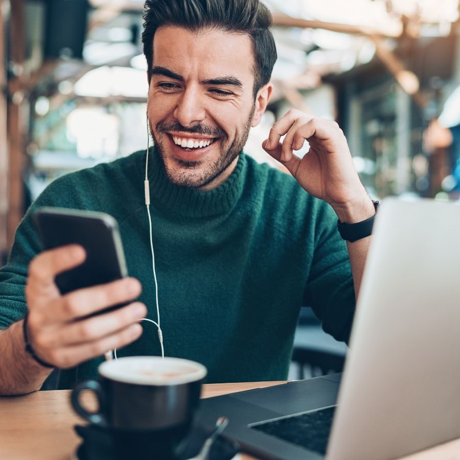 11 img of a man looking at a phone and a laptop