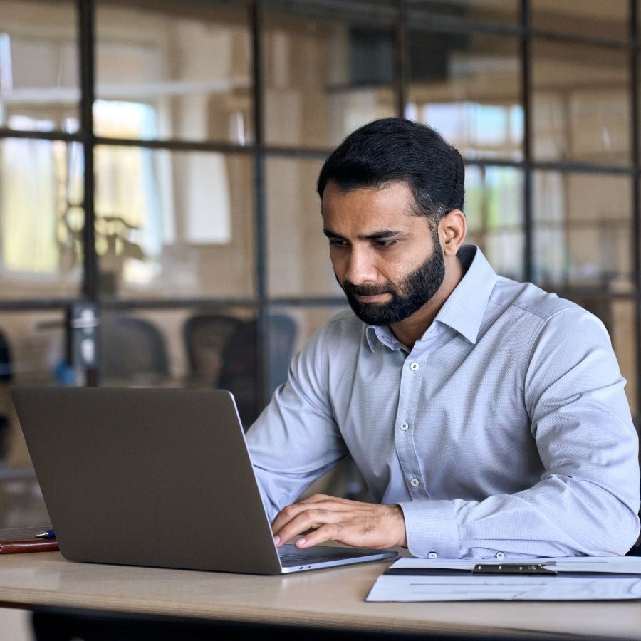 2 img of a man looking at a laptop