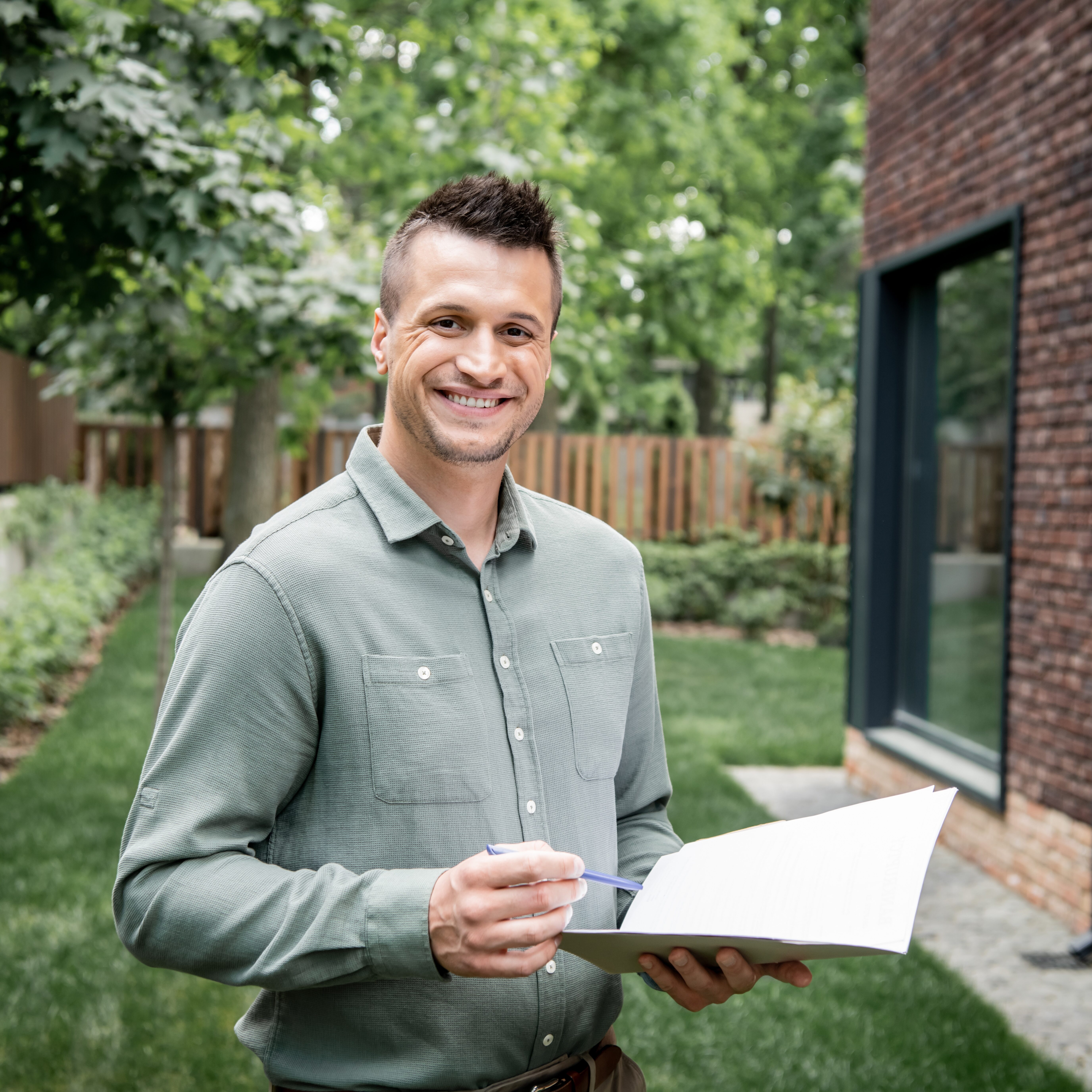 Overjoyed,Property,Broker,Looking,At,Camera,While,Standing,With,Folder